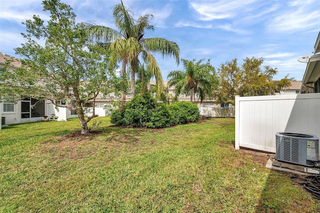 view of yard featuring central AC and fence