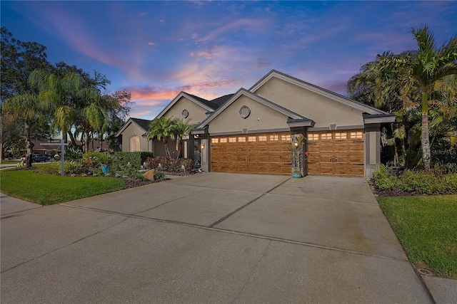 single story home with a garage, concrete driveway, and stucco siding