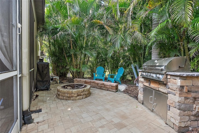 view of patio / terrace featuring exterior kitchen, an outdoor fire pit, and grilling area