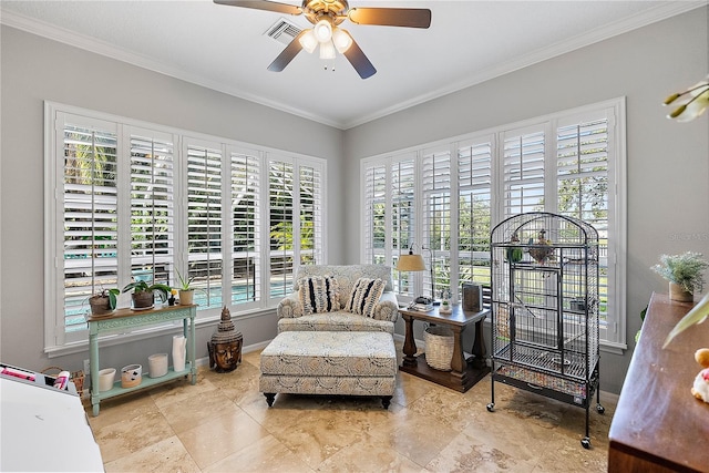 living area with visible vents, crown molding, baseboards, and ceiling fan