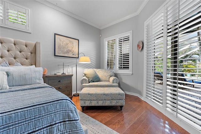 bedroom featuring baseboards, ornamental molding, and wood finished floors