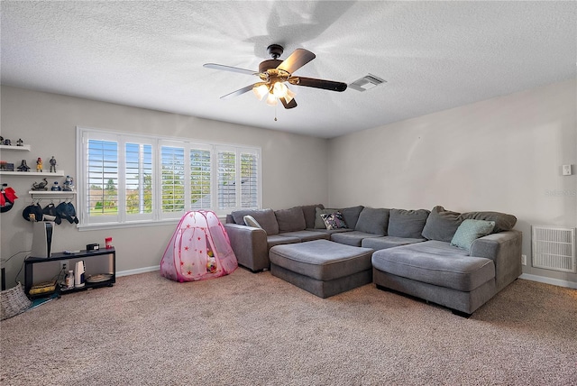 carpeted living area with visible vents, ceiling fan, a textured ceiling, and baseboards