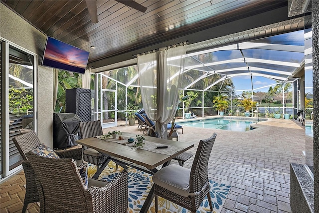 view of patio with a lanai, an outdoor pool, and grilling area