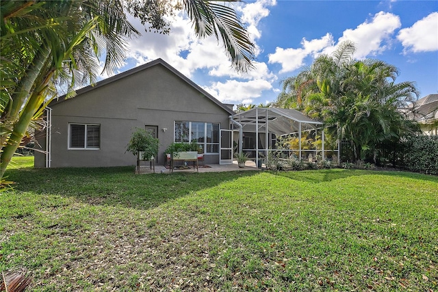 back of house with a lanai, a lawn, a patio, and stucco siding