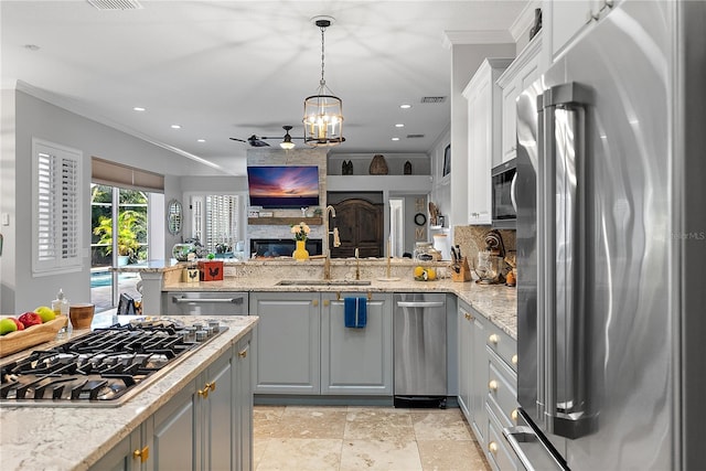 kitchen with crown molding, gray cabinets, backsplash, appliances with stainless steel finishes, and a sink