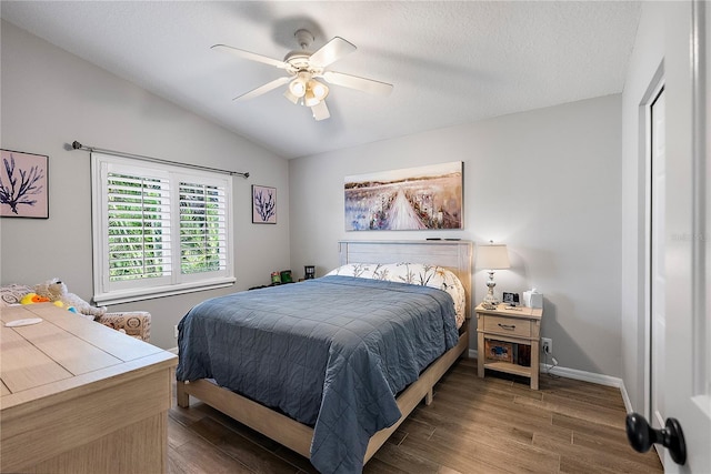 bedroom featuring a ceiling fan, vaulted ceiling, baseboards, and wood finished floors