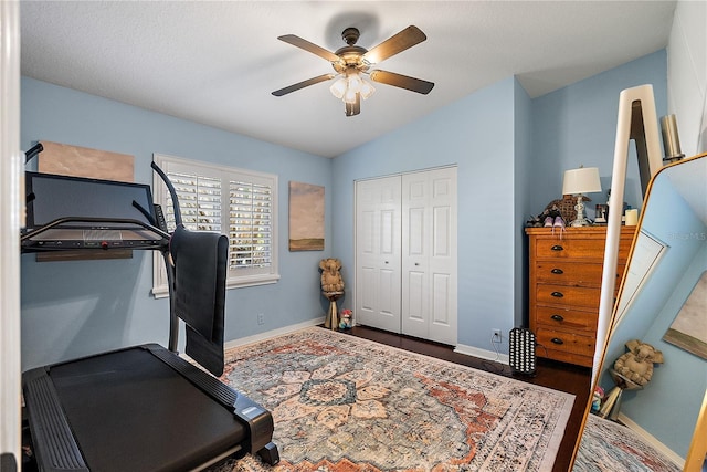 workout area featuring lofted ceiling, baseboards, and a ceiling fan