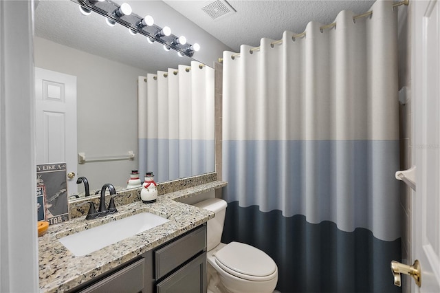 full bathroom featuring curtained shower, visible vents, toilet, a textured ceiling, and vanity