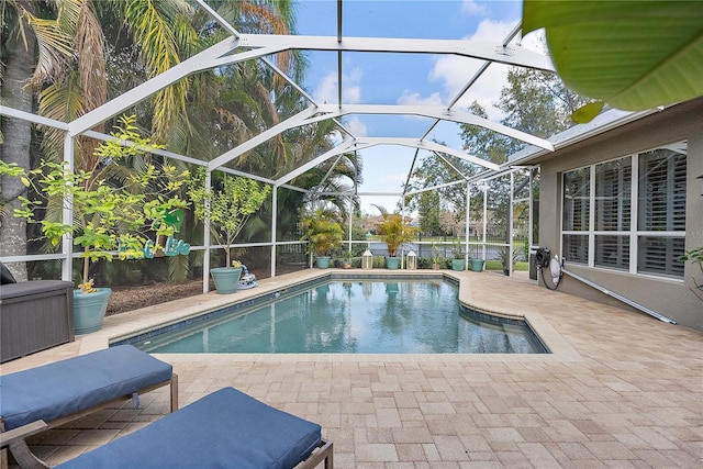 outdoor pool featuring glass enclosure and a patio