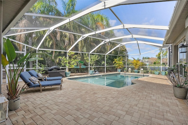 pool featuring glass enclosure and a patio area