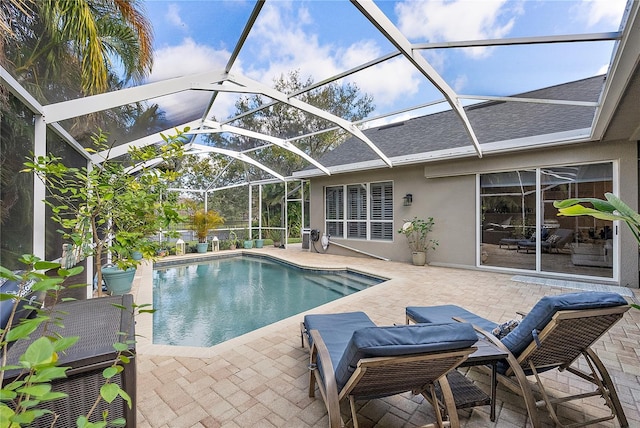 pool featuring glass enclosure and a patio