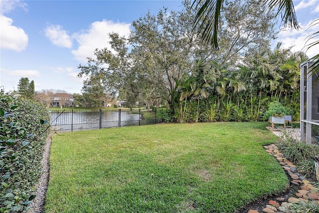 view of yard with a water view and fence