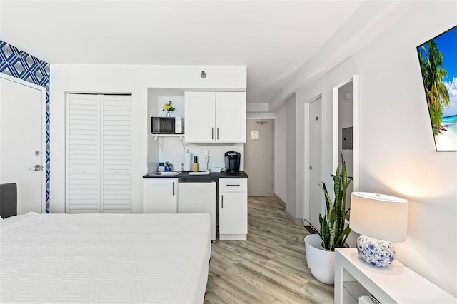 kitchen with white cabinets, light wood-type flooring, and fridge