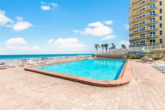 view of swimming pool with a patio and a water view