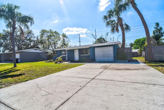 ranch-style house with an attached garage, fence, concrete driveway, and a front yard