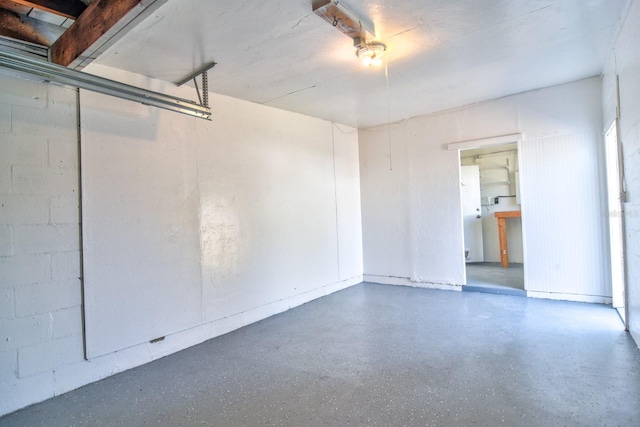 spare room with concrete block wall and speckled floor