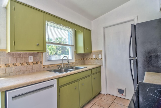 kitchen featuring light tile patterned floors, freestanding refrigerator, a sink, green cabinetry, and dishwasher