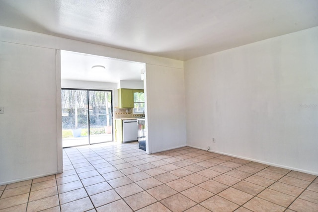 spare room featuring light tile patterned floors and baseboards