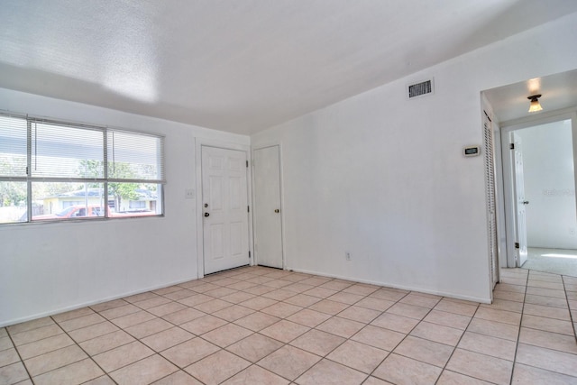 unfurnished room with light tile patterned flooring and visible vents