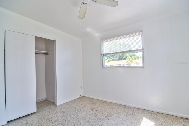 unfurnished bedroom with a ceiling fan, baseboards, a closet, and speckled floor