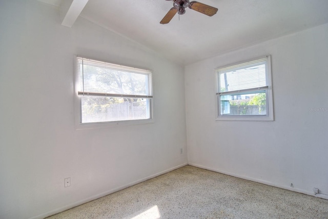 unfurnished room with speckled floor, beamed ceiling, a ceiling fan, and baseboards