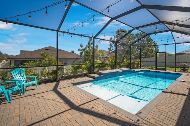 view of swimming pool featuring a patio and glass enclosure