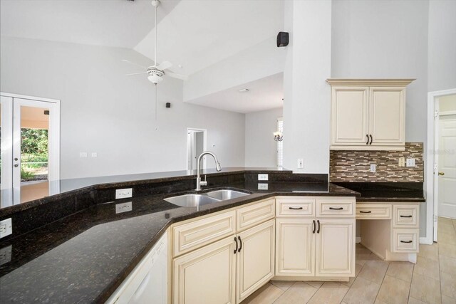 kitchen featuring dark stone counters, ceiling fan, white dishwasher, cream cabinetry, and a sink