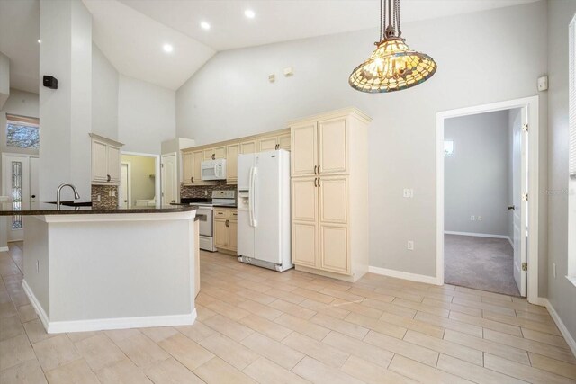 kitchen featuring hanging light fixtures, white appliances, high vaulted ceiling, and cream cabinetry