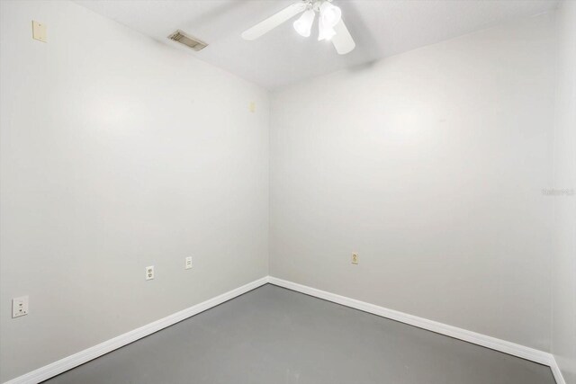 unfurnished room with concrete flooring, visible vents, baseboards, and a ceiling fan