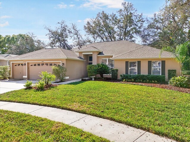 ranch-style home with an attached garage, driveway, a front lawn, and stucco siding