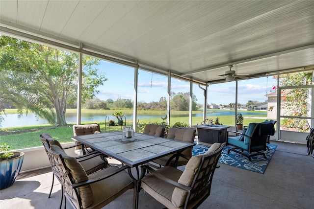 sunroom / solarium featuring a water view and ceiling fan