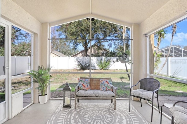 sunroom / solarium with a healthy amount of sunlight and lofted ceiling