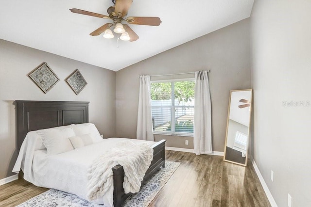 bedroom with hardwood / wood-style flooring, lofted ceiling, and ceiling fan