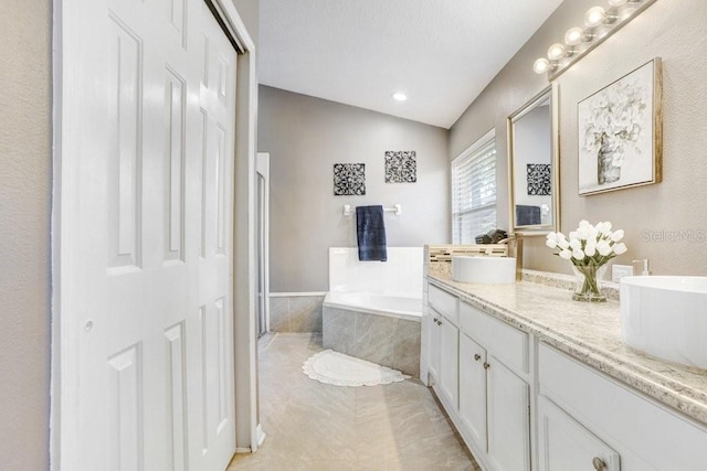 bathroom featuring separate shower and tub, lofted ceiling, tile patterned flooring, and vanity