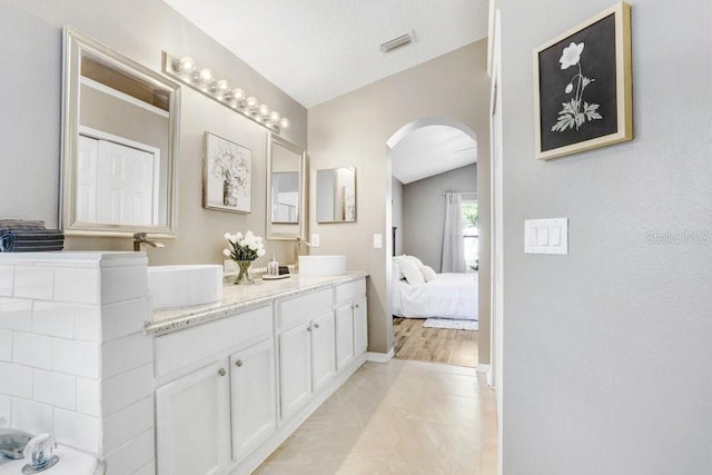 bathroom featuring lofted ceiling and vanity