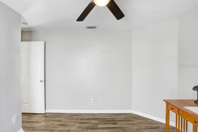 spare room featuring ceiling fan and dark wood-type flooring