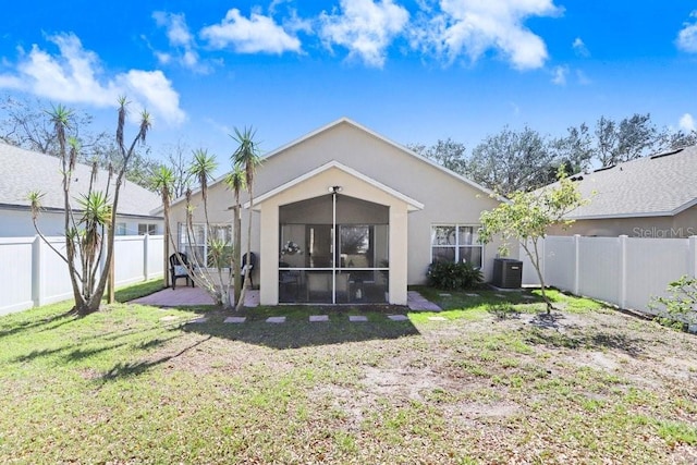 back of property featuring cooling unit, a yard, and a sunroom