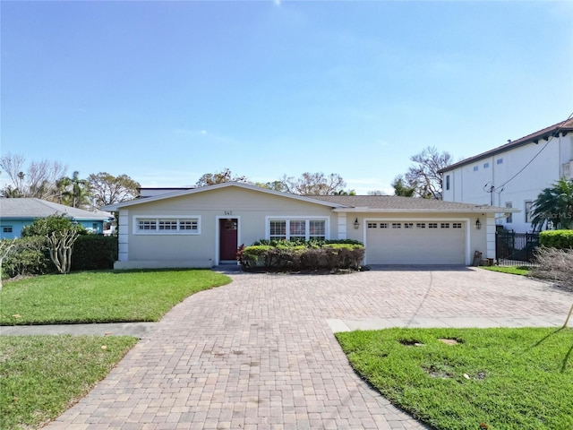 ranch-style home with a garage, a front yard, decorative driveway, and fence