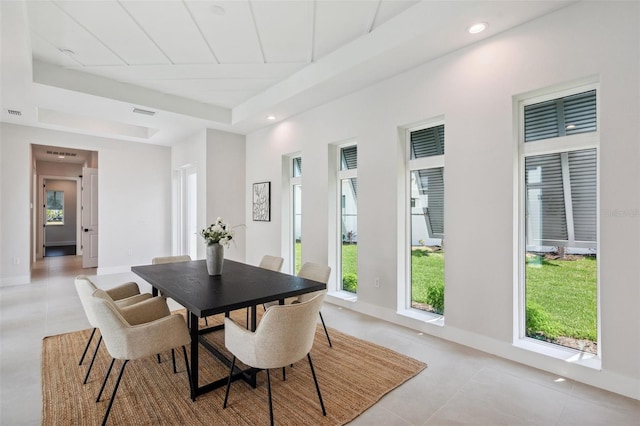 tiled dining room with a tray ceiling