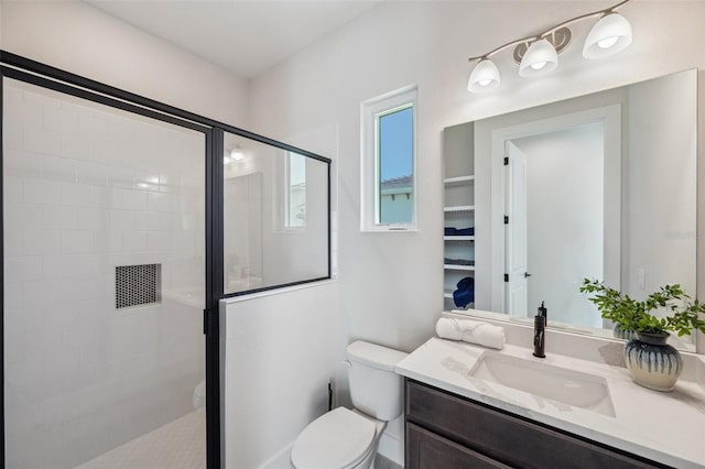 bathroom featuring vanity, a shower with door, and toilet