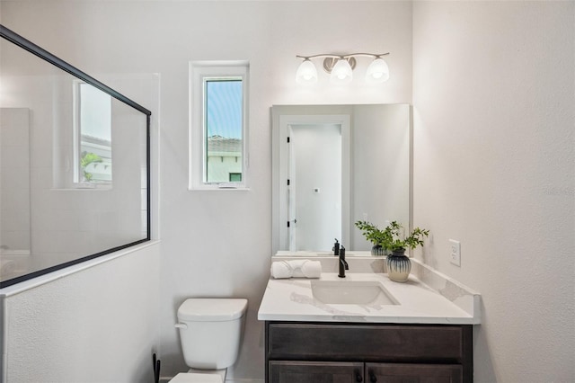 bathroom featuring vanity, toilet, and tiled shower