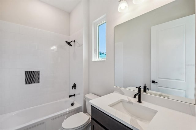 full bathroom with tiled shower / bath, vanity, and toilet