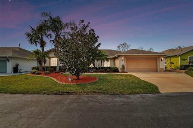 ranch-style home featuring a garage and a yard