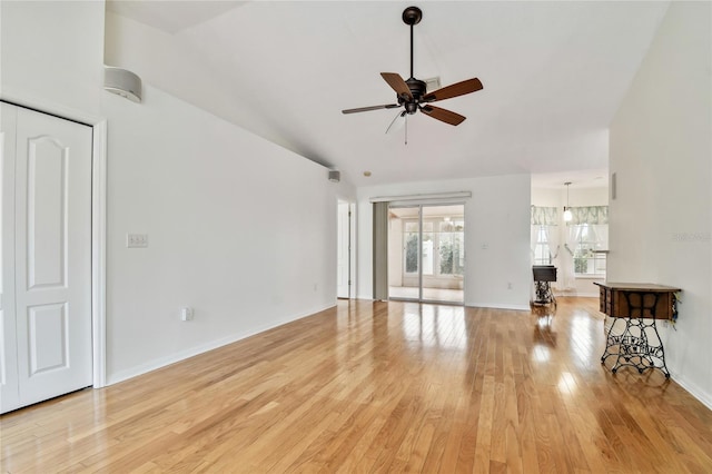 unfurnished living room with ceiling fan, light wood-type flooring, and vaulted ceiling