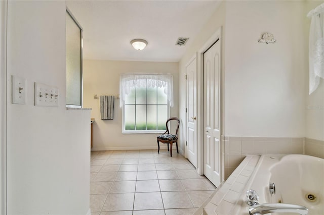 bathroom featuring tiled bath and tile patterned flooring