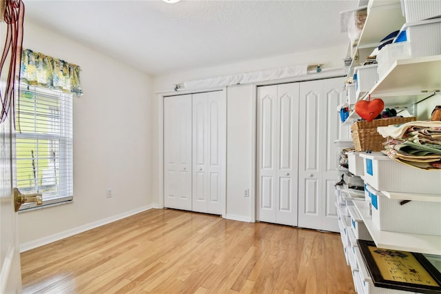 bedroom with light wood-type flooring and two closets