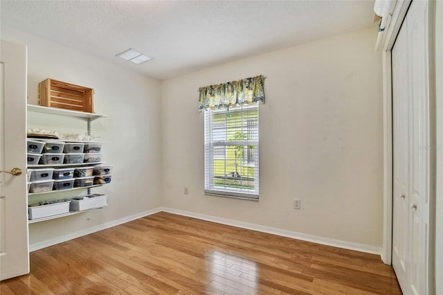 unfurnished bedroom with light wood-type flooring and a closet