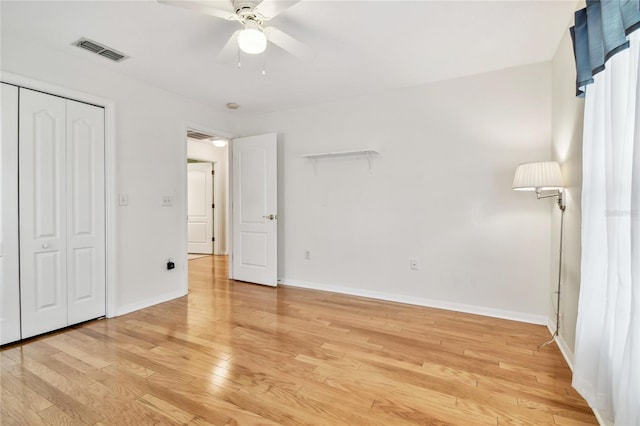 unfurnished bedroom with ceiling fan, light hardwood / wood-style flooring, and a closet