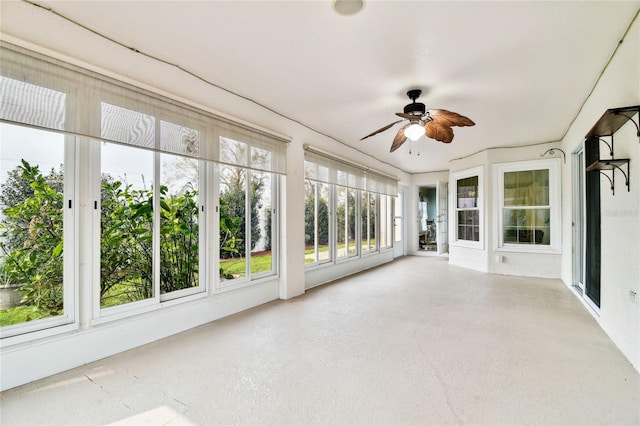 unfurnished sunroom with ceiling fan