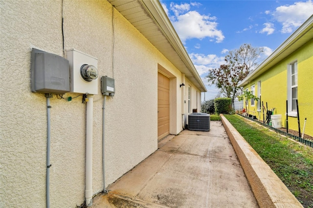 view of property exterior with central AC and a garage